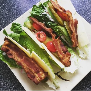 Romaine lettuce wraps with cheese, bacon, tomato, and pickles. 